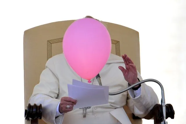 A balloon flies past Pope Francis during his general audience in St Peter's Square at the Vatican on May 14, 2014. (Photo by Tiziana Fabi/AFP Photo)