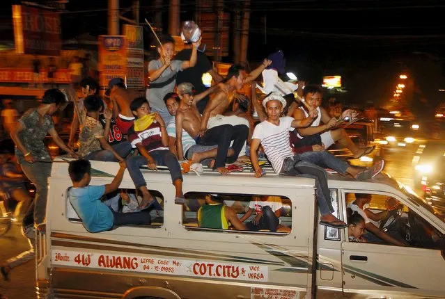 Filipino Muslims ride on top of a vehicle as they celebrate the end of the holy month of Ramadan in Cotabato city, in southern Philippines, July 16, 2015. Picture taken July 16, 2015. (Photo by Marconi Navales/Reuters)