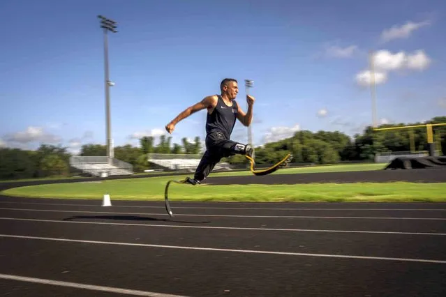 Luis Puertas runs with his prosthetic blades during one of his daily training sessions in a sports complex in Orlando, Fla., on Monday, August 9, 2021. He’s matter of fact about his injuries – “In the Paralympics everybody has a story. There’s always some guy whose story is worse”. But the first years were rough. (Photo by Emilio Morenatti/AP Photo)