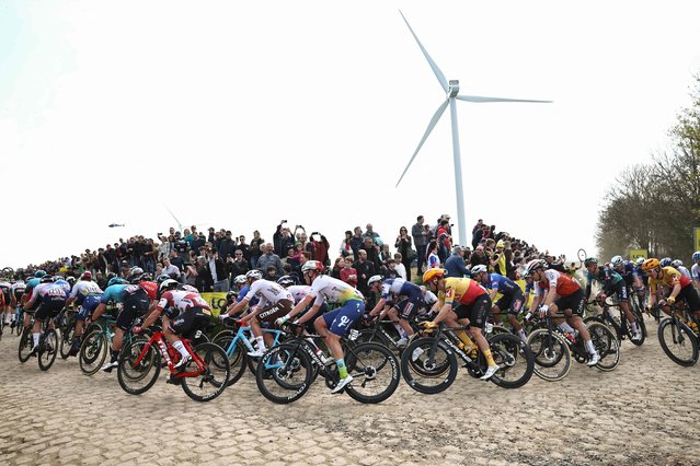 The pack of riders cycles over a cobblestone sector during the 120th edition of the Paris-Roubaix one-day classic cycling race, between Compiegne and Roubaix, northern France, on April 9, 2023. (Photo by Anne-Christine Poujoulat/AFP Photo)