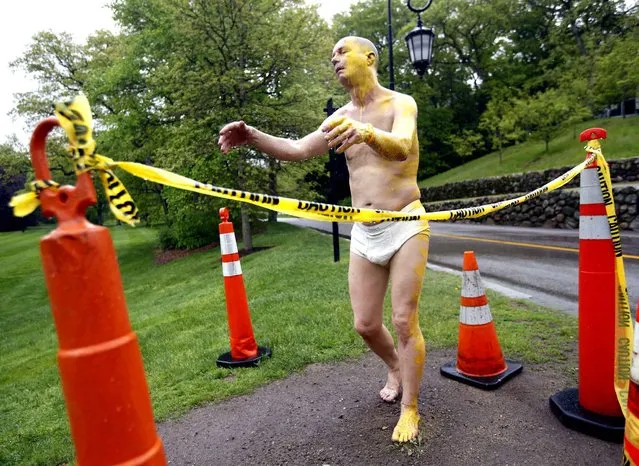 A fiberglass sculpture at Wellesley College, entitled “Sleepwalker”, is surrounded by cones and yellow caution tape, Wednesday, May 22, 2014, after being defaced Tuesday night with yellow paint on its face, left arm, left leg, and a foot. It was one of several properties on campus vandalized, and campus police are investigating. The outdoor, lifelike sculpture of a man sleepwalking in his underpants had provoked some concern on the college campus in February. (Photo by Elise Amendola/AP Photo)