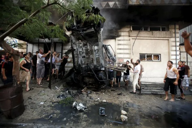Palestinians inspect a car after it was blown up in Gaza City July 19, 2015. The spokesman for Gaza's interior ministry said that a number of cars belonging to Palestinian factions were blown up by vandals and the security services started to investigate the incident. (Photo by Suhaib Salem/Reuters)
