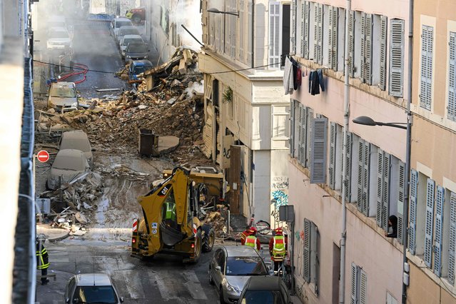 Firefighters stand next to a truck moving rubbles where a building collapsed in Marseille, southern France, on April 9, 2023. “We have to be prepared to have victims”, the mayor of Marseille warned on April 9, 2023 after a four-storey apartment building collapsed in the centre of France's second city, injuring five people, according to a provisional report. (Photo by Nicolas Tucat/AFP Photo)