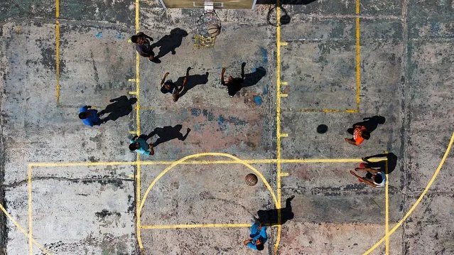 Locals play basketball at Petare slum in Caracas, Venezuela, on September 29, 2019. (Photo by Matias Delacroix/AFP Photo)