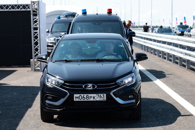 In this pool photograph distributed by the Russian state agency Sputnik, Russia's President Vladimir Putin drives a Lada Aura car as he arrives to launch traffic on the new section of the M-11 motorway – known as the “Neva” highway – connecting Moscow and Saint Petersburg, in the Tver region on July 16, 2024. (Photo by Vyacheslav Prokofyev/Pool via AFP Photo)