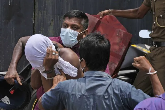 An anti-government protestor, left, is roughed up Sri Lankan government supporters outside prime minister's office in Colombo, Sri Lanka, Monday, May 9, 2022. Sri Lankan Prime Minister Mahinda Rajapaksa resigned Monday following weeks of protests demanding that he and his brother, the president, step down over the country’s worst economic crisis in decades, an official said. (Photo by Eranga Jayawardena/AP Photo)