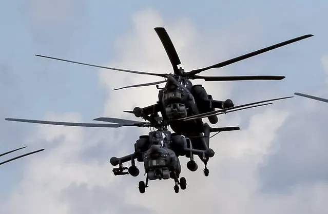 Russian Mi-28Ns from the Berkuty (Golden Eagles) helicopter display team fly in formation during the Aviadarts military aviation competition at the Dubrovichi range near Ryazan, Russia, August 2, 2015. (Photo by Maxim Shemetov/Reuters)