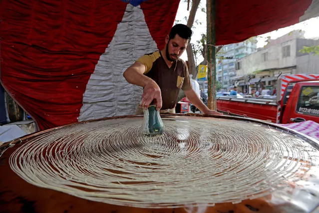 An Egyptian baker prepares Kanafeh, a traditional Middle Eastern dessert sold during Muslims fasting month of Ramadan, at a market in shubra Misr district on April 6, 2022 in Cairo, Egypt. (Photo by Fadel Dawod/Getty Images)