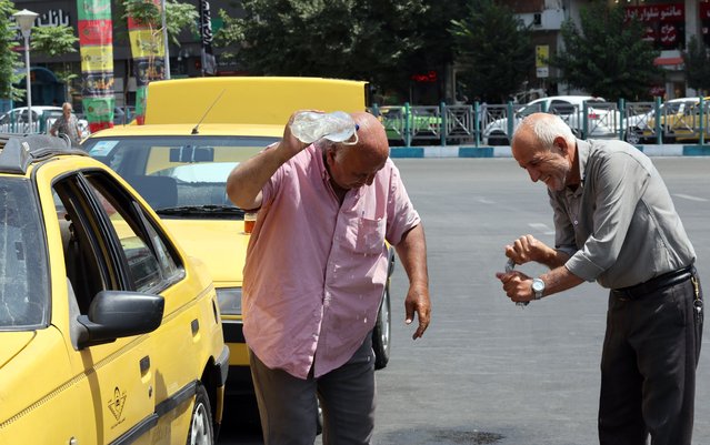 Iranian taxi drivers cool off during hot weather in Tehran, Iran, 22 July 2024. Iran is facing a heatwave with temperatures expected to reach 40 degrees Celsius. (Photo by Abedin Taherkenareh//EPA/EFE)