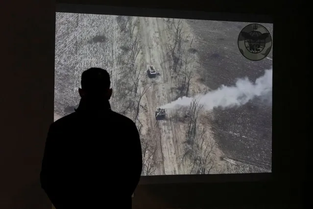 A man watches a drone video of an attack to a Russian tank at an exhibition of the ongoing Russian invasion of Ukraine, in the National Museum of the History of Ukraine in the Second World War, as Russia celebrates Victory Day marking the 77th anniversary of the victory over Nazi Germany in World War Two, in Kyiv, Ukraine on May 9, 2022. (Photo by Carlos Barria/Reuters)