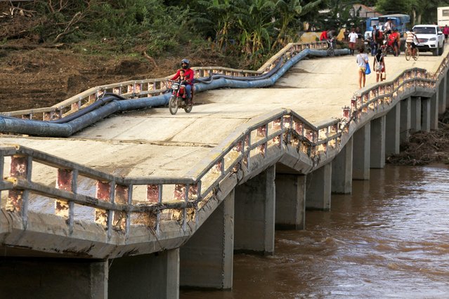 People walk across the bridge affected by Hurricane Oscar a week after it hit the town of Imias in Guantanamo province, Cuba on October 30, 2024. (Photo by Ariel Ley/Reuters)
