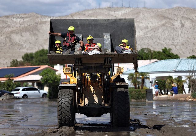 Elderly residents are rescued by members of the Cathedral City Fire Department in a bulldozer on August 21, 2023 in Cathedral City, California. Much of Southern California and parts of Arizona and Nevada are cleaning up after being impacted by Tropical Storm Hilary that brought several inches of rain that flooded roadways and winds that toppled trees and power lines across the region. (Photo by Mario Tama/Getty Images)
