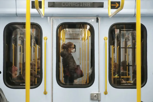 A woman wearing a face mask stands in a subway train in Milan, Italy, Thursday, March 5, 2020. Italy's virus outbreak has been concentrated in the northern region of Lombardy, but fears over how the virus is spreading inside and outside the country has prompted the government to close all schools and Universities nationwide for two weeks. (Photo by Antonio Calanni/AP Photo)