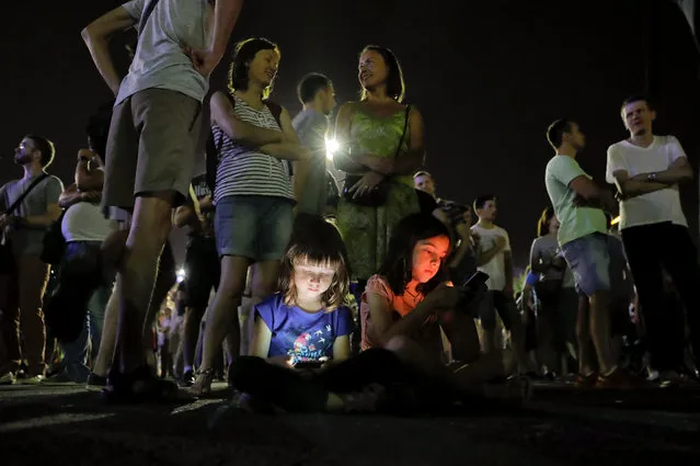 Children's faces are illuminated by mobile phone screens as protesters stand outside the government headquarters in Bucharest, Romania, Sunday, August 27, 2017. According to officials more than 1,000 people have protested in Bucharest and other Romanian cities against a series of proposals presented by Justice Minister Tudorel Toader, that critics say will reverse the anti-corruption fight. (Photo by Vadim Ghirda/AP Photo)