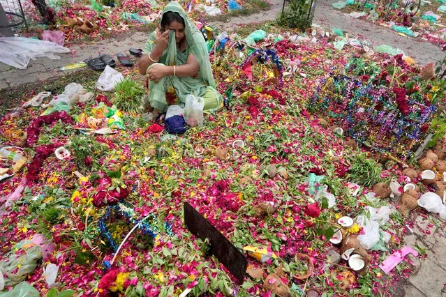 A woman mourns at a graveyard during Diwaso festival in Ahmedabad, India, Thursday, July 28, 2022. Members of Devipujak community gather at graveyards to mourn and offer gifts to deceased relatives during this annual festival. (Photo by Ajit Solanki/AP Photo)