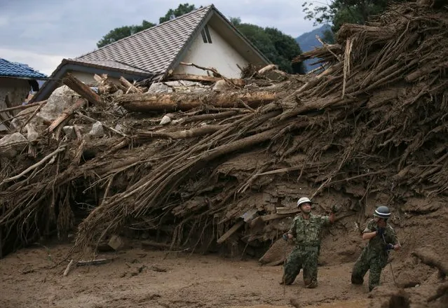 Japan Self-Defense Force (JSDF) soldiers search for survivors at a site where a landslide swept through a residential area at Asaminami ward in Hiroshima, western Japan, August 20, 2014. At least 36 people, including several children, were killed in Japan on Wednesday, when landslides triggered by torrential rain slammed into the outskirts of the western city of Hiroshima, and the toll could rise further, police said. (Photo by Toru Hanai/Reuters)