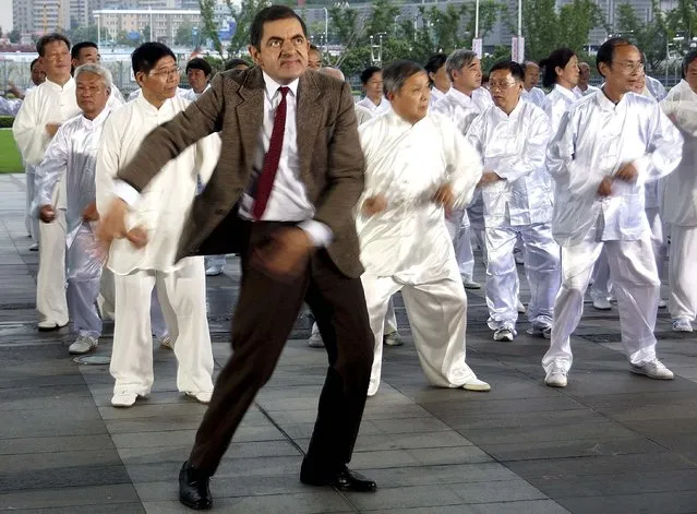 British actor Rowan Atkinson (front), dressed in his popular television character Mr. Bean, dances with Chinese performers during the filming of a promotional video in Shanghai August 20, 2014. (Photo by Reuters/Stringer)