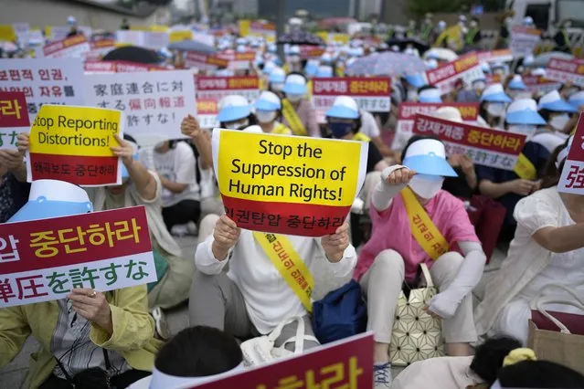 Unification Church followers hold signs during a rally in downtown Seoul, South Korea, Thursday, August 18, 2022, protesting negative Japanese media coverage of their religion after the suspect in the assassination of former Japanese Prime Minster Shinzo Abe blamed the church for his family’s troubles. (Photo by Lee Jin-man/AP Photo)