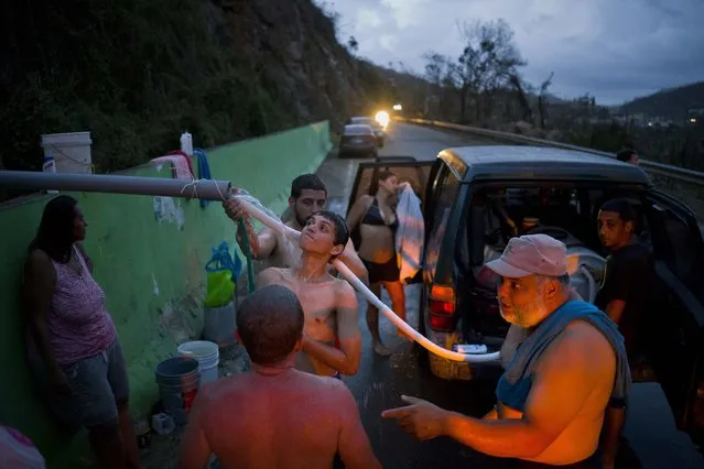 People affected by Hurricane Maria bathe in and collect water piped from a creek in the mountains, in Naranjito, Puerto Rico, Thursday, September 28, 2017. (Photo by Ramon Espinosa/AP Photo)