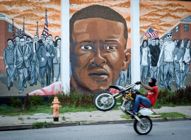 A motorcyclist passes a mural of the late Freddie Gray in the Sandtown neighborhood of Baltimore, Maryland, U.S., July 27, 2016. (Photo by Bryan Woolston/Reuters)