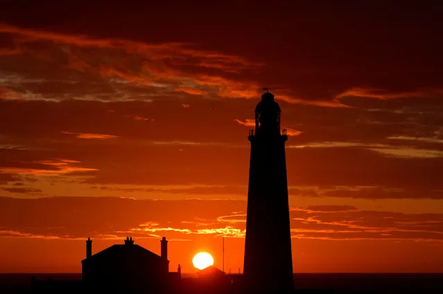 The sun rises behind St Mary’s lighthouse in Whitley Bay, Tyneside, UK on August 6, 2015. (Photo by Owen Humphreys/PA Wire)