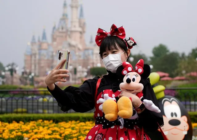 A visitor dressed as a Disney character takes a selfie while wearing a protective face mask at Shanghai Disney Resort as the Shanghai Disneyland theme park reopens following a shutdown due to the coronavirus disease (COVID-19) outbreak, in Shanghai, China on May 11, 2020. (Photo by Aly Song/Reuters)