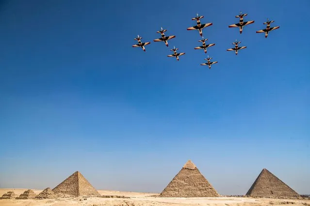 K-8E Karakorum aircraft of the Egyptian Air Force “Silver Stars” aerobatic team perform during the Pyramids Air Show 2022 above the (R to L) Great Pyramid of Khufu, the Pyramid of Khafre, and the Pyramid of Menkaure at the Giza Pyramids Necropolis on the southwestern outskirts of the Egyptian capital on August 3, 2022. (Photo by Mahmoud Khaled/AFP Photo)