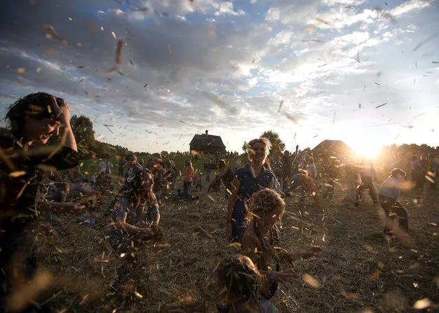 People dance and throw straw during a traditionnal festival in village Ozerco, some 10 km from Minsk, on September 6, 2014. (Photo by Uladz Hrydzin/AFP Photo)
