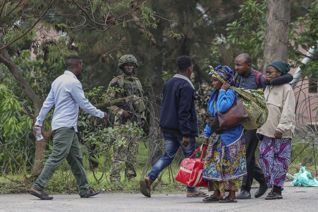 A member of the M23 armed group holds position behind barbed wire as civilians fleeing ongoing clashes in eastern Democratic Republic of Congo cross the border into Rwanda at the La Corniche Border Post in Gisenyi on January 29, 2025. The fate of DR Congo's besieged city of Goma appeared to be all but sealed on January 29, 2025, after Rwandan-backed fighters seized control of the airport and most of the centre and neighbourhoods of the key mineral trading hub. (Photo by Tony Karumba/AFP Photo)