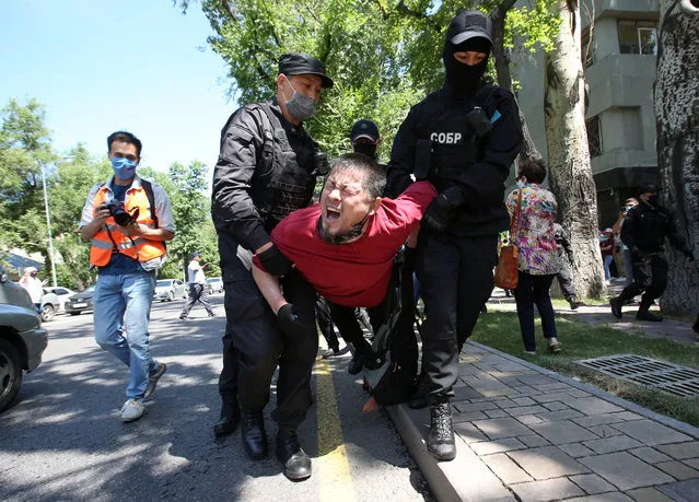Kazakh law enforcement officers wearing protective face masks, which are used as a preventive measure against the coronavirus disease (COVID-19), detain a man during an unsanctioned rally held by opposition supporters in Almaty, Kazakhstan on June 6, 2020. (Photo by Pavel Mikheyev/Reuters)