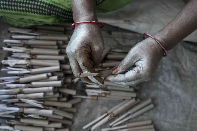 A worker makes firecrackers for the upcoming Hindu festival Diwali at a factory on the outskirts of Ahmedabad, India, Sunday, October 16, 2022. Fire crackers are in huge demand in India during Diwali, the festival of lights, which will be celebrated on October 24. (Photo by Ajit Solanki/AP Photo)