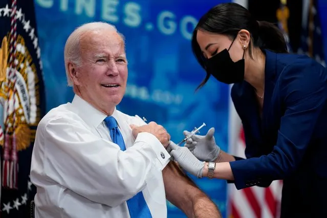 President Joe Biden receives his COVID-19 booster from a member of the White House medical unit during an event in the South Court Auditorium on the White House campus, Tuesday, October 25, 2022, in Washington. (Photo by Evan Vucci/AP Photo)