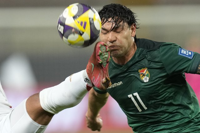 Bolivia's Carmelo Algaranaz attempts to head the ball as Peru's Miguel Trauco kicks it during a FIFA World Cup 2026 qualifying soccer match in Lima, Peru, Thursday, March 20, 2025. (Photo by Martin Mejia/AP Photo)