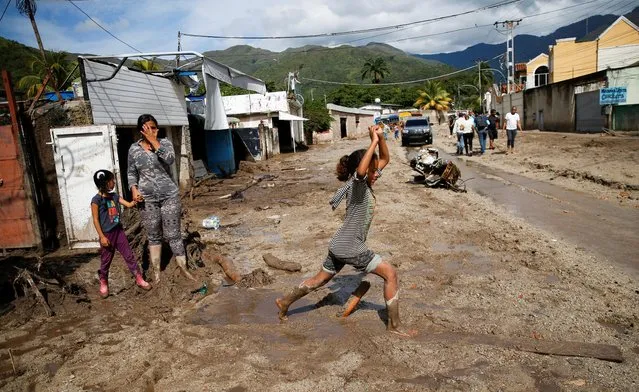 A girl walks in mud caused by the devastating floods following heavy rain in the neighbourhood of Los Castanos, in Maracay, Aragua state, Venezuela on October 18, 2022. (Photo by Leonardo Fernandez Viloria/Reuters)