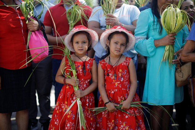 Children look on as Catholic worshippers wait to take part in a Palm Sunday procession, as the Holy Week begins, in Suchitoto, El Salvador on April 13, 2025. (Photo by Jose Cabezas/Reuters)