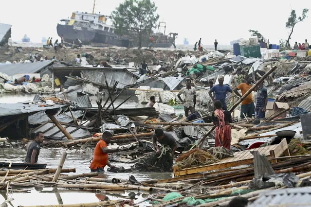 Residents search for their belongings amid the debis of their collapsed huts after the cyclone Sitrang hits in Chittagong on October 25, 2022. At least nine people have died after a cyclone slammed into Bangladesh, forcing the evacuation of around a million people from their homes, officials said. (Photo by Rabin Chowdhury/AFP Photo)