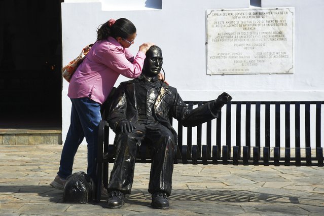 A woman embraces a statue of José Gregorio Hernandez, the physician known as the “doctor of the poor”, in Valencia, Venezuela, Tuesday, February 25, 2025. Pope Francis on Tuesday approved a decree to canonize Hernandez, making him Venezuela's first saint. (Photo by Jacinto Oliveros/AP Photo)
