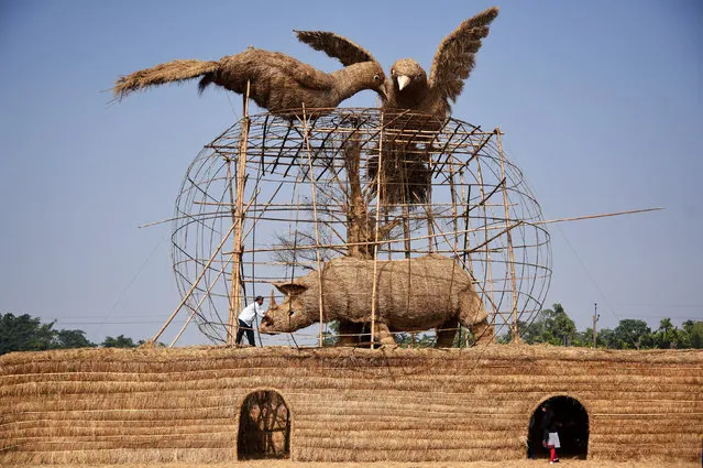 A worker prepares a makeshift cottage called “Bhelaghar”, which is made of bamboo and straw, as part of celebrations ahead of the Magh Bihu festival in Morigaon district, in the northeastern state of Assam, India, January 9, 2018. (Photo by Anuwar Hazarika/Reuters)