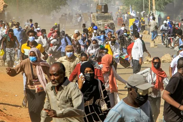 Protesters flee before a Sudanese security forces armed vehicle in clashes during a demonstration against a tentative deal aimed at ending the crisis provoked by last year's military coup, in the Bashdar district in the south of Sudan's capital Khartoum on December 19, 2022. Thousands of pro-democracy activists took to the streets in the Sudanese capital, protesting the agreement signed by military and civilian leaders on December 5, which critics have dismissed as vague. The demonstration coincided with the fourth anniversary of the outbreak of months-long mass protests that ousted long-time autocrat Omar al-Bashir in April 2019. (Photo by AFP Photo/Stringer)