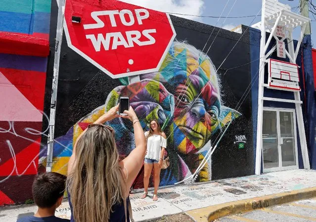 Visitors take pictures of art on buildings in the Wynwood arts district of Miami, Florida, U.S. August 3, 2016. (Photo by Joe Skipper/Reuters)