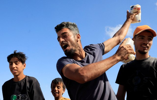A person gestures while holding food supplies as palestinians gather near an aid distribution site run by the U.S.-backed Gaza Humanitarian Foundation, in Rafah, in the southern Gaza Strip, on May 27, 2025. (Photo by Hatem Khaled/Reuters)