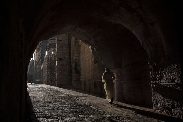 A woman walks on an alley in the Old City of Jerusalem, Sunday, March 10, 2024. Officials in Saudi Arabia have declared the start of the fasting month of Ramadan after sighting the crescent moon Sunday night. The announcement marks the beginning of Ramadan for many of the world's 1.8 billion Muslims. (Photo by Leo Correa/AP Photo)