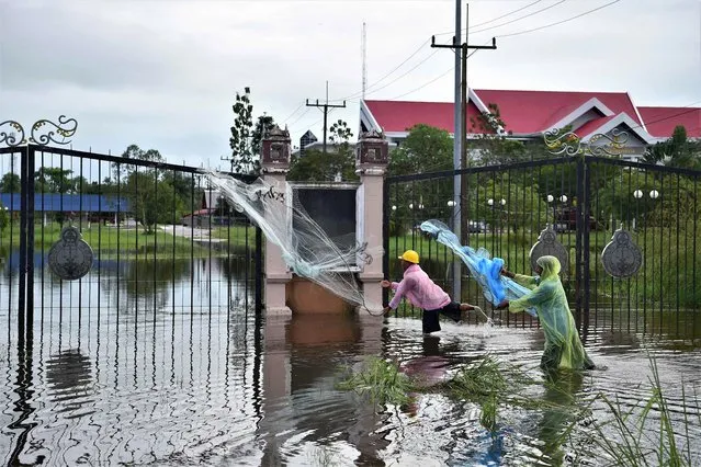 Men throw nets as they fish in floodwaters following heavy rains in the southern Thai province of Narathiwat on December 20, 2022. (Photo by Madaree Tohlala/AFP Photo)