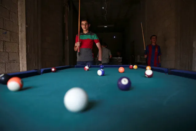 Youth play billiards on the last day of Eid al-Adha celebrations in the rebel held besieged town of Hamouriyeh, eastern Ghouta, near Damascus, Syria September 15, 2016. (Photo by Bassam Khabieh/Reuters)