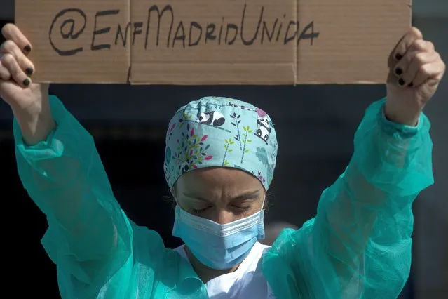 A nurse wearing wearing a face mask to prevent the spread of coronavirus gathers during a protest demanding an improvement in wages and labor conditions at La Paz hospital in Madrid, Spain, Monday, October 5, 2020. Madrid has been the source of Europe's most worrying surge of infections in the ongoing second wave of the pandemic. (Photo by Manu Fernandez/AP Photo)