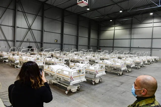A journalist takes a picture of beds prepared in a field hospital, which will function as a backup device for patients with coronavirus, in the Letnany neighbourhood at the Prague outskirts, Czech Republic, Thursday, October 22, 2020. (Photo by Roman Vondrous/AP Photo via CTK)