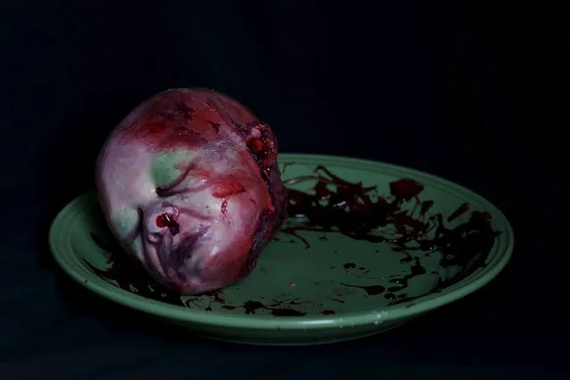 A bloody zombie baby head made of gummy candy and red jelly is pictured at the Zombie Gourmet homemade candy manufacturer on the outskirts of Mexico City October 30, 2015. (Photo by Carlos Jasso/Reuters)