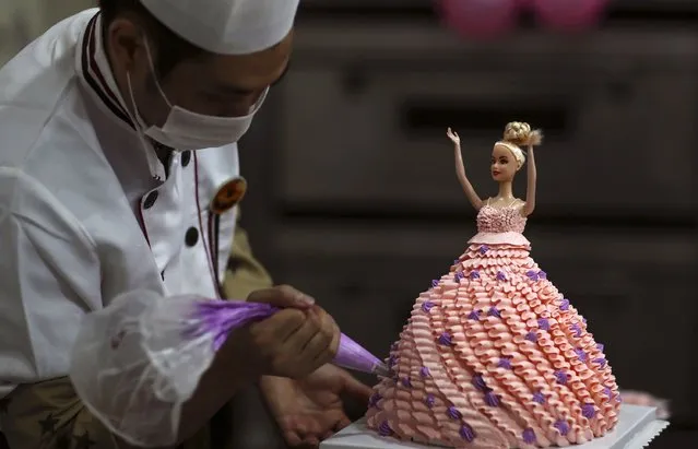 A pastry chef makes a “Barbie Doll Cake” at a dessert shop in Kunming, Yunnan province December 7, 2014. A barbie doll cake costs 188 yuan (31 USD). (Photo by Wong Campion/Reuters)
