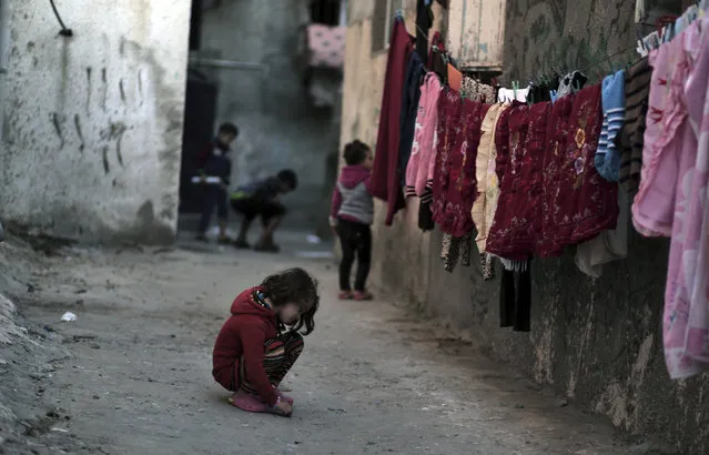 In this Thursday January 11, 2018 photo, Palestinian children play in an alley at the Shati refugee camp in Gaza City. From the Gaza Strip to Jordan and Lebanon, millions of Palestinians are bracing for the worst as the Trump administration moves toward cutting funding to the U.N. agency that assists Palestinian refugees across the region. The expected cuts could deliver a painful blow to some of the weakest populations in the Middle East and risk destabilizing the already struggling countries that host displaced Palestinian refugees and their descendants. (Photo by Khalil Hamra/AP Photo)