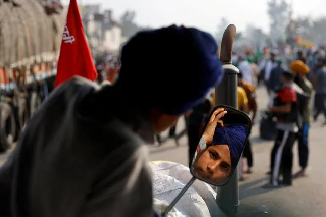 A boy adjusts his turban at a site of a protest by farmers against the newly passed farm bills at Singhu border near Delhi, India, November 30, 2020. (Photo by Danish Siddiqui/Reuters)